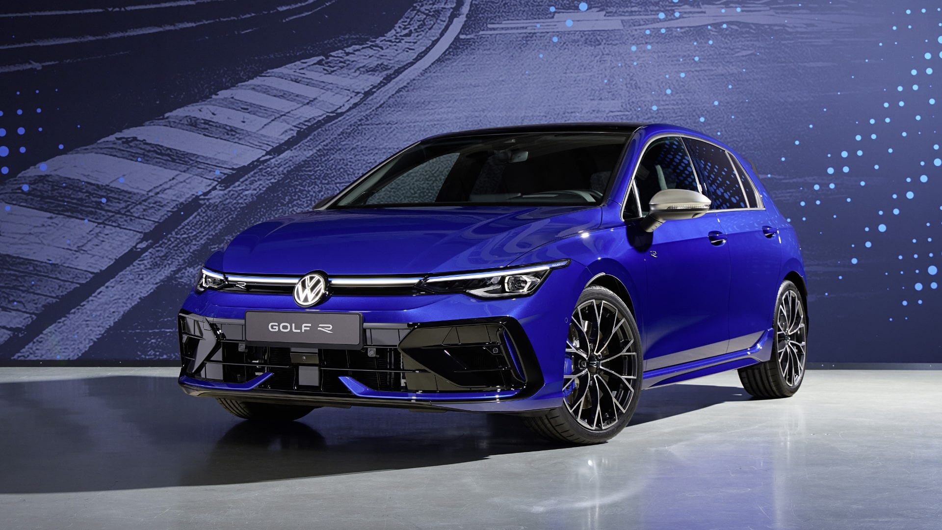 Front view of a blue Volkswagen Golf R featuring a new bumper and headlights.