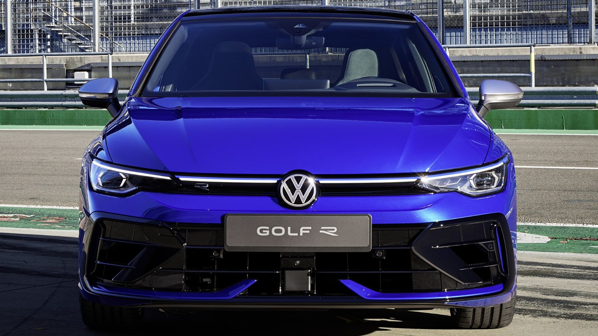 Blue Volkswagen Golf R on a racetrack.