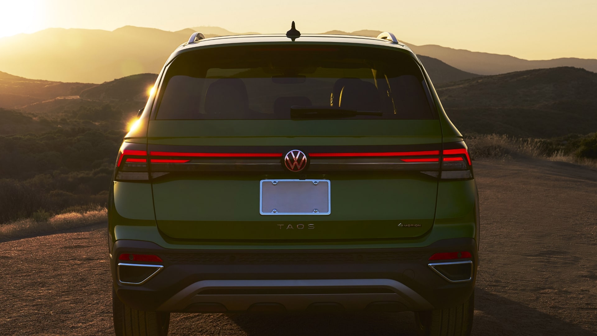 Arrière d'un Volkswagen Taos 2025 vert au coucher du soleil.