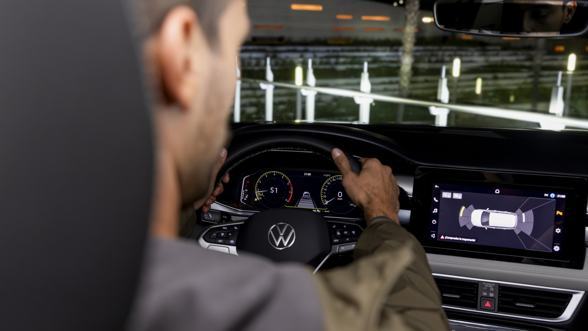 Driver viewing Park Distance Control display on a Volkswagen infotainment screen.