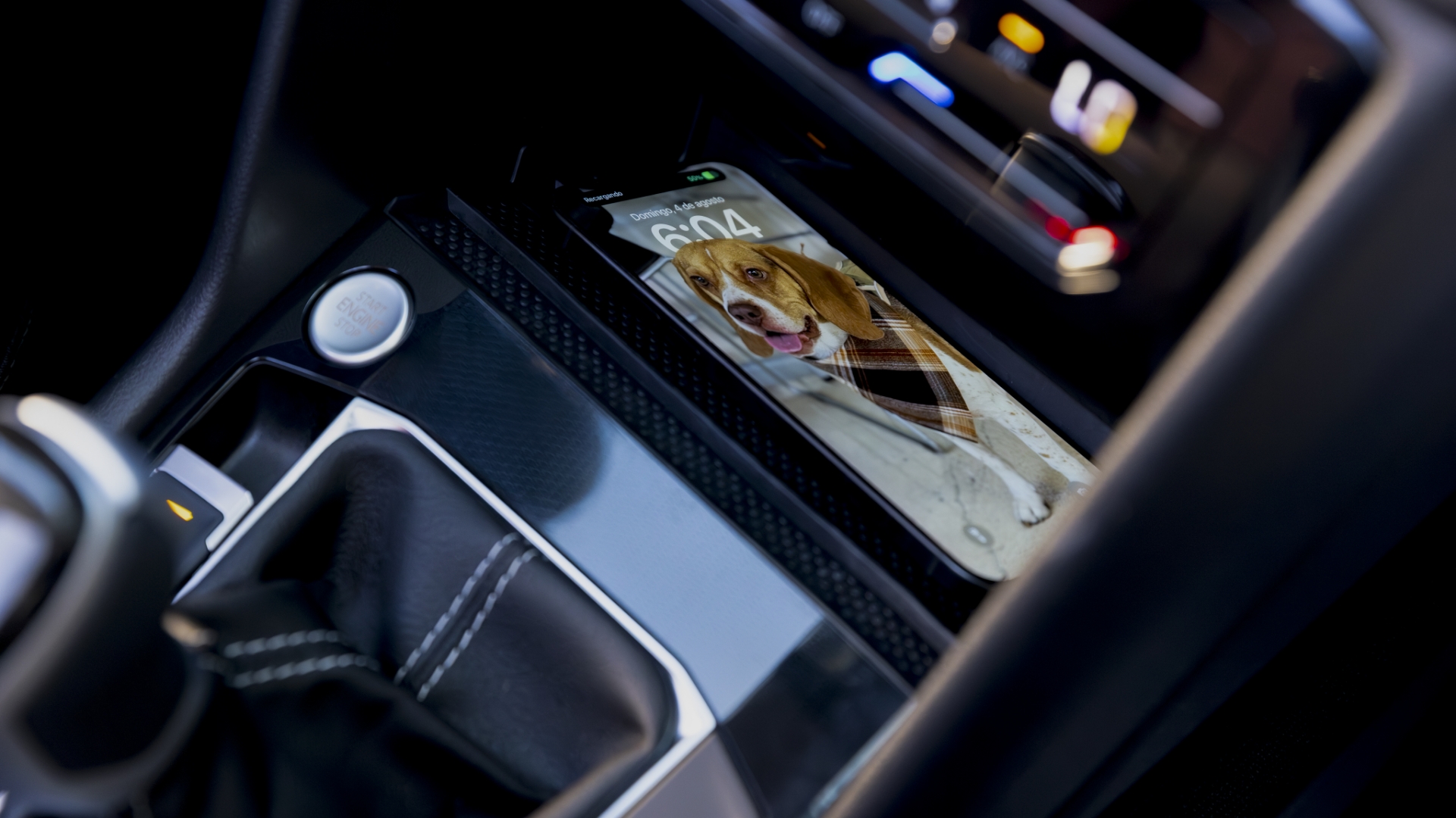 A wireless charging pad holding a smartphone inside the car, emphasizing modern convenience.